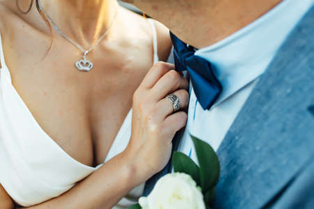 Close-up portrait of a bride and groom standing on the city street and lovely hugging