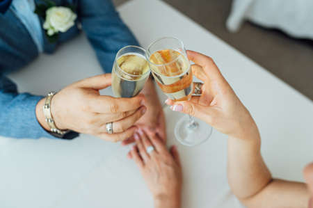 Bride and groom hold in their hands glasses with wineの写真素材