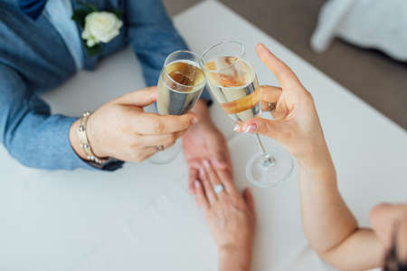 Bride and groom hold in their hands glasses with wineの写真素材