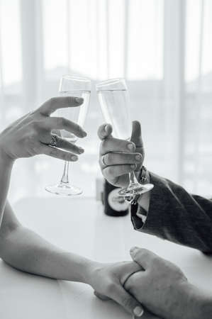Bride and groom hold in their hands glasses with wineの写真素材