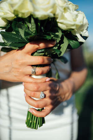 Bride holding white wedding bouquet of roses and love flowerの写真素材