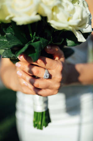 Bride holding white wedding bouquet of roses and love flowerの写真素材