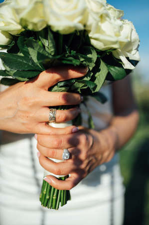 Bride holding white wedding bouquet of roses and love flowerの写真素材