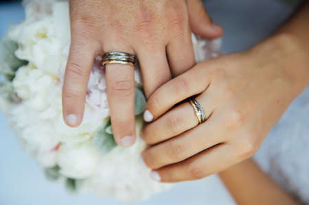 Hands of newlyweds with wedding rings - bride and groom at a wedding ceremonyの写真素材
