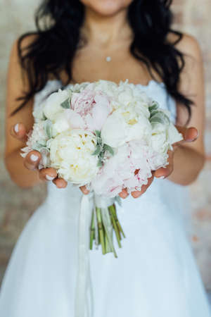 Bride holding white wedding bouquet of roses and love flowerの写真素材