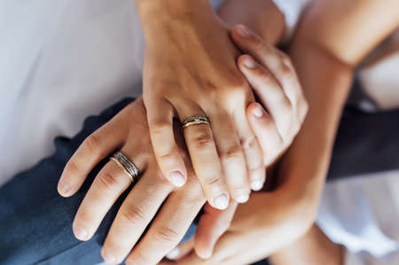 close-up portrait of the bride and groom. They hug their arms. Wedding rings on their handsの写真素材