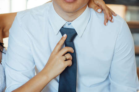 Man groom in wedding suit with bow tie. Hands bride, care, fix, adjust, fashionの写真素材