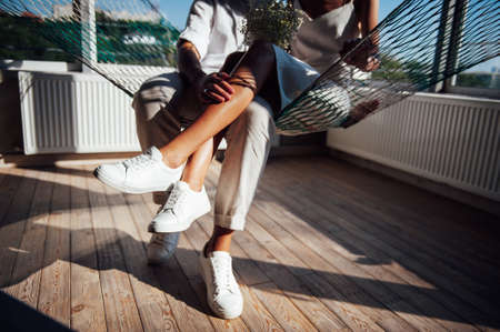 Couple in love has fun on a mesh hammock, in the sunの写真素材