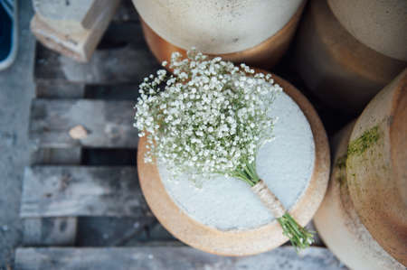 A beautiful wedding bouquet of gypsophila lies on a clay jugの写真素材