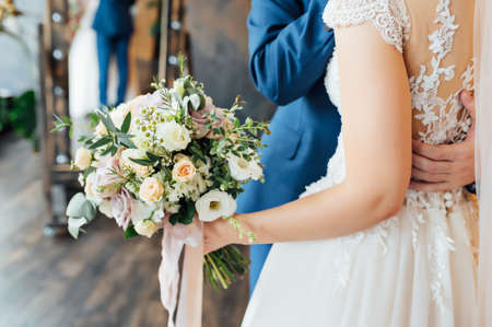 legal husband and wife hugging with a bouquet in their hands after the ceremonyの写真素材