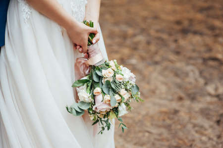 the bride is holding a beautiful lush wedding bouquet.の写真素材