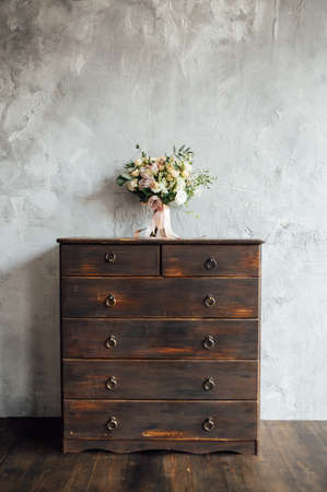 wedding bouquet on dresser near gray wall with vintage textureの写真素材