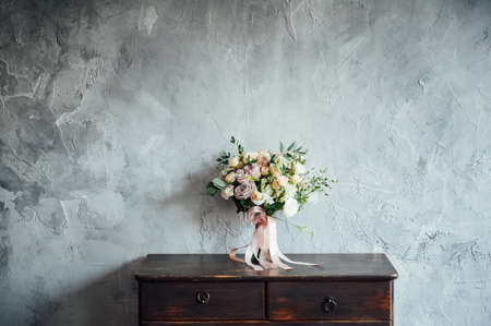 wedding bouquet on dresser near gray wall with vintage textureの写真素材