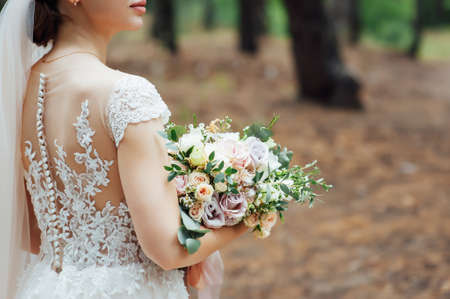 the bride is holding a beautiful lush wedding bouquet.の写真素材