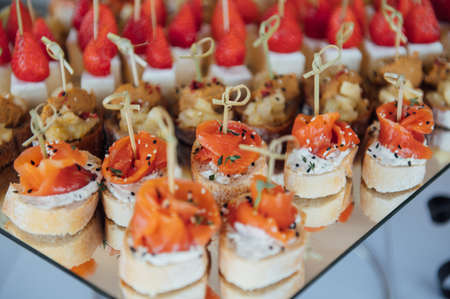 Sandwiches, canapes and cakes on the festive table. A wide variety of snacksの写真素材