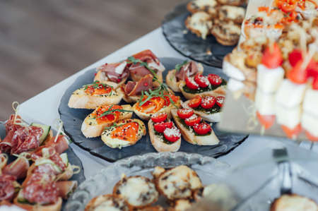 Sandwiches, canapes and cakes on the festive table. A wide variety of snacks
