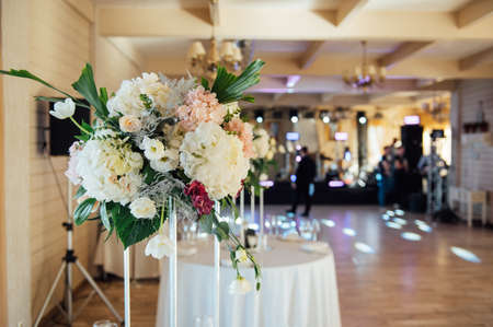A beautiful vase of flowers on a table in a luxury restaurant. Wedding decorationsの写真素材