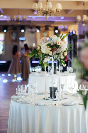 A beautiful vase of flowers on a table in a luxury restaurant. Wedding decorationsの写真素材