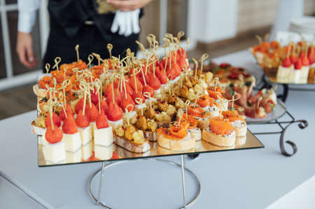 Sandwiches, canapes and cakes on the festive table. A wide variety of snacksの写真素材