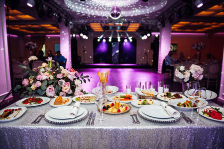 Luxurious restaurant. Luxurious interior, white tables, serving dishes and glasses for guestsの写真素材