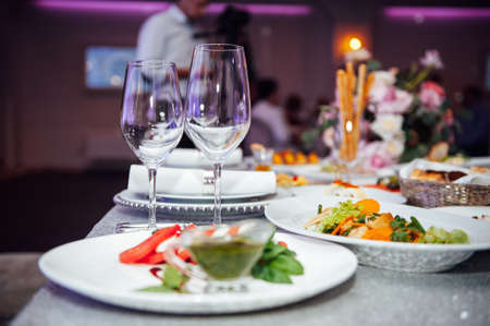 Luxurious restaurant. Luxurious interior, white tables, serving dishes and glasses for guestsの写真素材