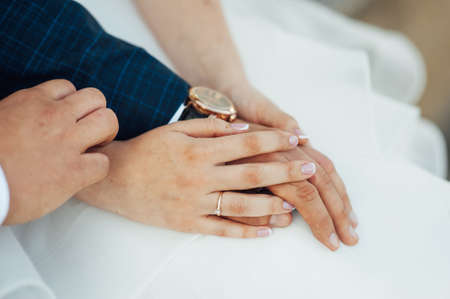 close-up portrait of the bride and groom. They hug their arms. Wedding rings on their handsの写真素材