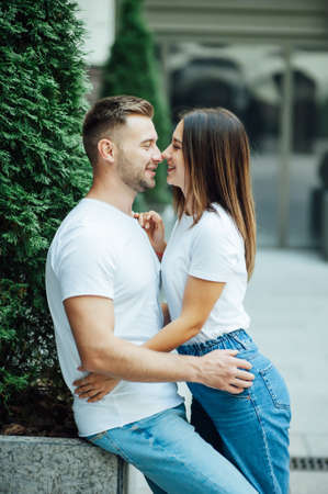 Fashion outdoor romantic portrait of beautiful young couple in love and hugs on the street.の写真素材
