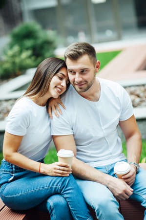 Fashion outdoor romantic portrait of beautiful young couple in love and hugs on the street.の写真素材