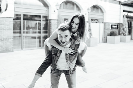 Fashion outdoor romantic portrait of beautiful young couple in love and hugs on the street.の写真素材