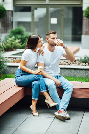 Fashion outdoor romantic portrait of beautiful young couple in love and hugs on the street.の写真素材