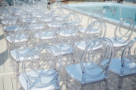 Glass chairs stand in a row in a beautiful wedding outing ceremonyの写真素材