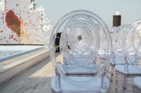 Glass chairs stand in a row in a beautiful wedding outing ceremonyの写真素材
