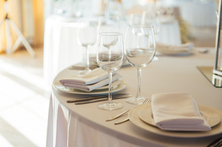 Luxurious restaurant. Luxurious interior, white tables, serving dishes and glasses for guestsの写真素材