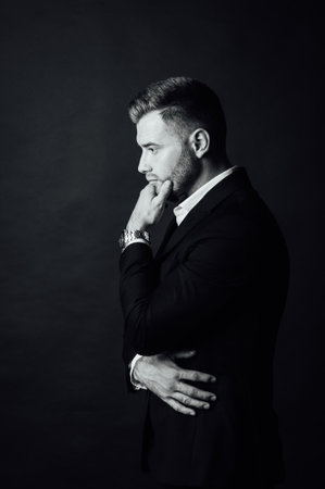 Handsome male businessman with suit posing in a photo studio. Half-length portraitの写真素材