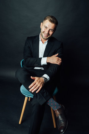 Handsome businessman man sitting on chair in photo studioの写真素材