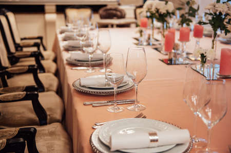 Luxurious restaurant. Luxurious interior, white tables, serving dishes and glasses for guestsの写真素材
