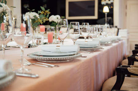 Luxurious restaurant. Luxurious interior, white tables, serving dishes and glasses for guestsの写真素材