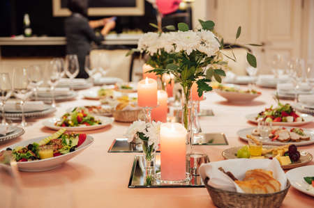 Luxurious restaurant. Luxurious interior, white tables, serving dishes and glasses for guestsの写真素材