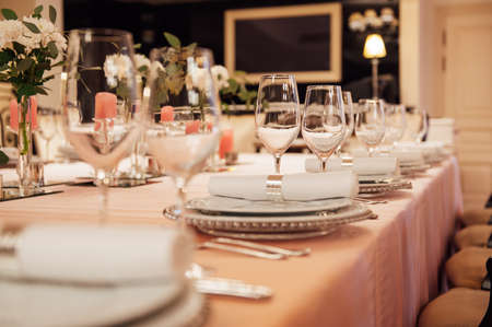 Luxurious restaurant. Luxurious interior, white tables, serving dishes and glasses for guestsの写真素材