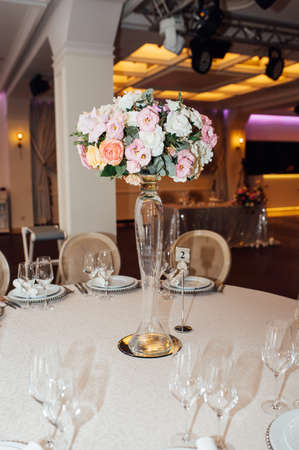 Luxurious restaurant. Luxurious interior, white tables, serving dishes and glasses for guestsの写真素材