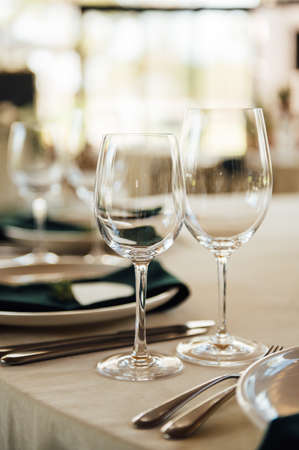 Luxurious restaurant. Luxurious interior, white tables, serving dishes and glasses for guestsの写真素材