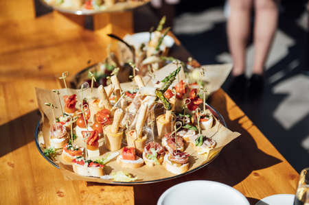 Sandwiches, canapes and cakes on the festive table. A wide variety of snacksの写真素材