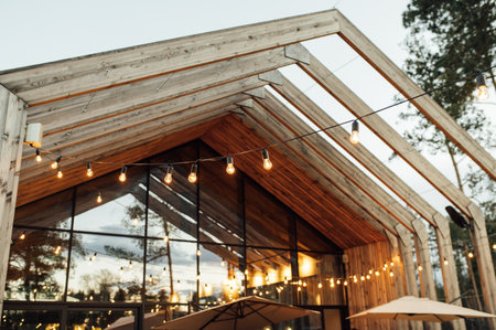 Evening illumination in the courtyard with the background of a modern wooden houseの写真素材