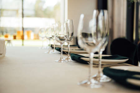Luxurious restaurant. Luxurious interior, white tables, serving dishes and glasses for guestsの写真素材