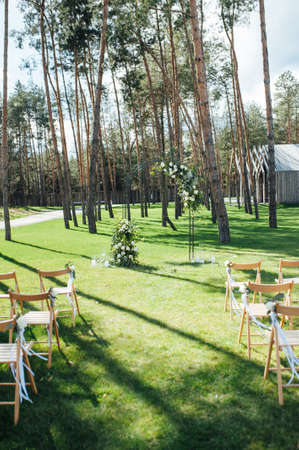 Very beautiful outside ceremony. classical wedding in forest. Metal arch with flowers.の写真素材