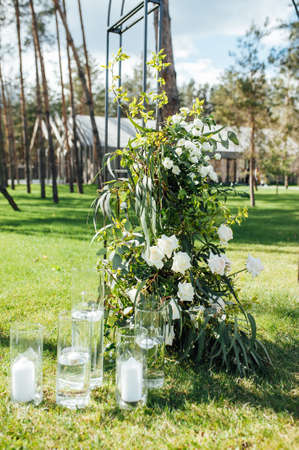 Very beautiful outside ceremony. classical wedding in forest. Metal arch with flowers.の写真素材