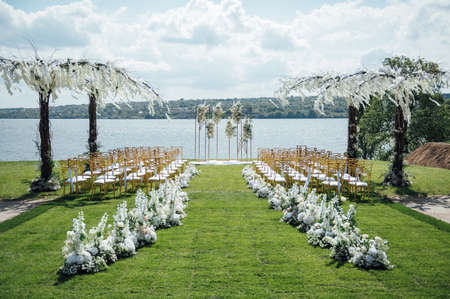 Premium arch for wedding ceremony for newlyweds on the river bank with wisteria treesの写真素材