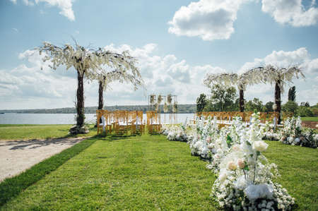 Premium arch for wedding ceremony for newlyweds on the river bank with wisteria treesの写真素材