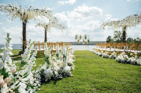 Premium arch for wedding ceremony for newlyweds on the river bank with wisteria treesの写真素材