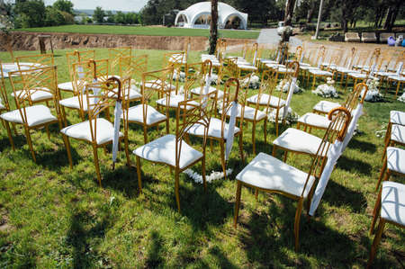 Festive wedding ceremony. Hanging umbrella on an empty chairの写真素材